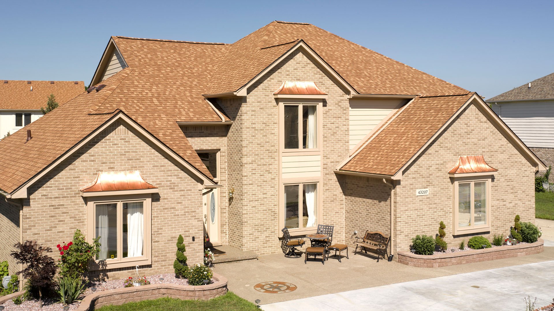 Home with light brown shingles that match the design
